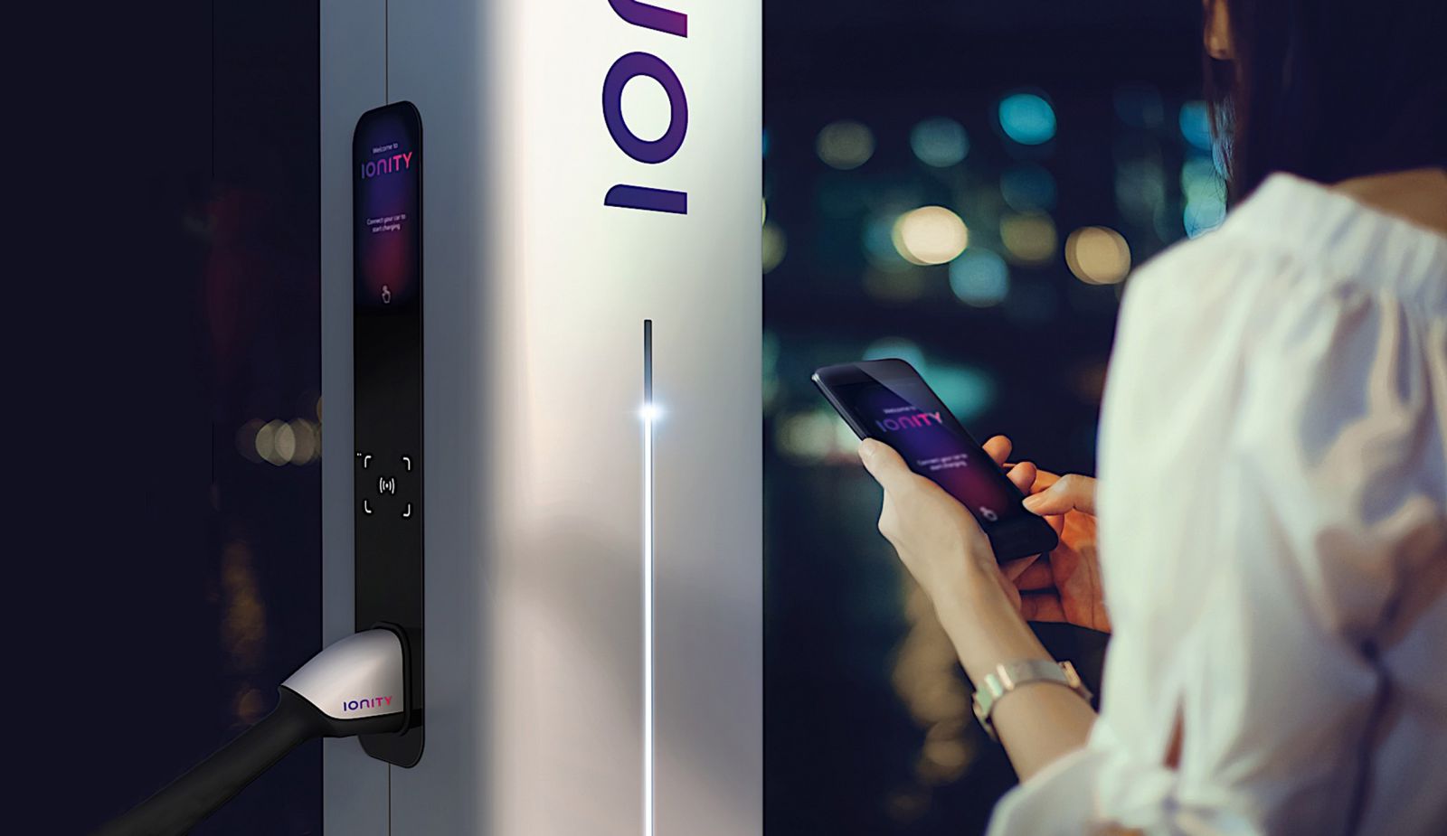 women standing in front of ionity charging station